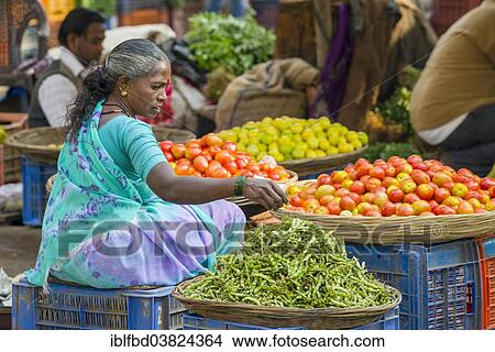 Picture - "A woman is selling chilis and tomatoes at the weekly vegetable market, Nasik, Maharashtra, India, Asia". Fotosearch