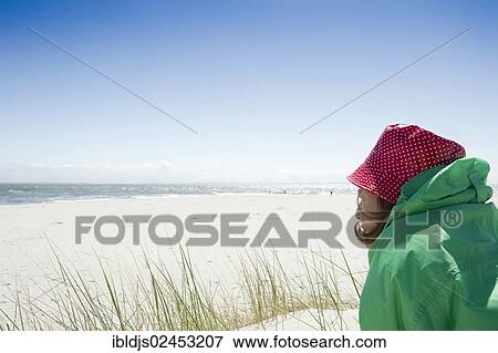 Stock Photo - "A woman sitting on the beach, Sylt, Germany, Europe". Fotosearch