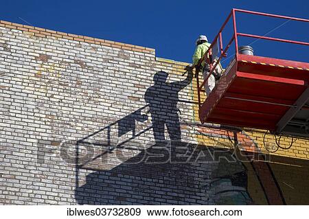 Stock Photo - "A worker repairs a mural on a wall at Eastern Market, Detroit, Michigan, United States, North America". Fotosearch