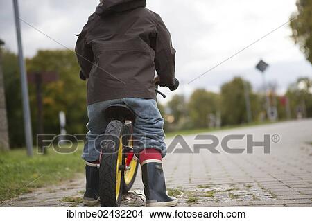 "A young boy is practicing to ride a bicycle on a quiet street, Brandenburg, Germany, Europe" View Large Photo Image Picture - "A young boy is practicing to ride a bicycle on a quiet street, Brandenburg, Germany, Europe". Fotosearch