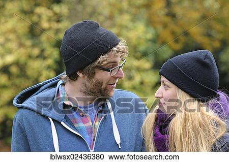 Stock Image - "A young couple is having a conversation in an autumnal park, Baden-Wuerttemberg, Germany, Europe, PublicGround, Europe". Fotosearch