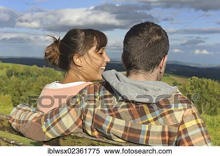Stock Photography - "A young couple sitting on a bench, Hegaublick, Baden-Wuerttemberg, Germany, Europe, PublicGround, Europe". Fotosearch