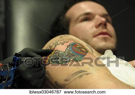 Stock Photo - "A young man is getting a tattoo, Freiburg im Breisgau, Baden-Wurttemberg, Germany, Europe". Fotosearch