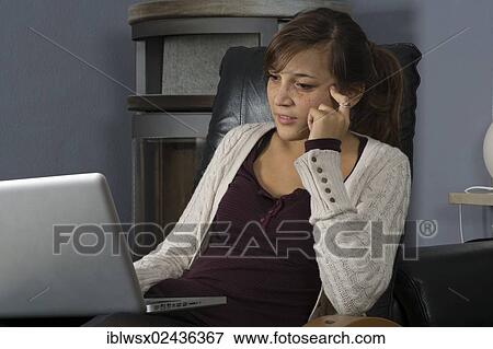 "A young woman of Indonesian origin is sitting in front of a wood burner working on a laptop computer, Germany, Europe" View Large Photo Image Stock Photo - "A young woman of Indonesian origin is sitting in front of a wood burner working on a laptop computer, Germany, Europe". Fotosearch