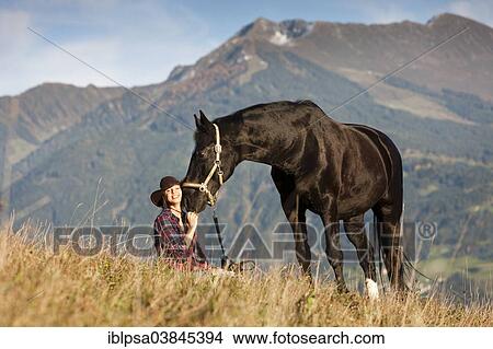 "A young woman with a black Hanoverian horse on a mountain meadow in autumn, North Tyrol, Austria, Europe" View Large Photo Image Picture - "A young woman with a black Hanoverian horse on a mountain meadow in autumn, North Tyrol, Austria, Europe". Fotosearch