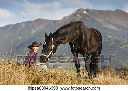 "A young woman with a black Hanoverian horse on a mountain meadow in autumn, North Tyrol, Austria, Europe" View Large Photo Image Stock Image - "A young woman with a black Hanoverian horse on a mountain meadow in autumn, North Tyrol, Austria, Europe". Fotosearch