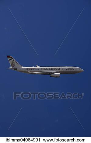 Stock Image - A6-EYK Etihad Airways Airbus A330-243 in flight against a blue sky. Fotosearch