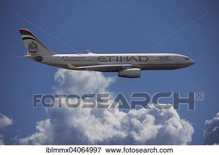 Stock Photo - A6-EYK Etihad Airways Airbus A330-243 in flight against a cloudy sky. Fotosearch
