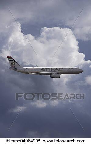 Stock Photography - A6-EYK Etihad Airways Airbus A330-243 in flight against a cloudy sky. Fotosearch