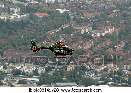Stock Photo - "Aerial photo, police helicopter in flight over Rostock, Rostock, Mecklenburg-Western Pomerania, Germany, Europe". Fotosearch