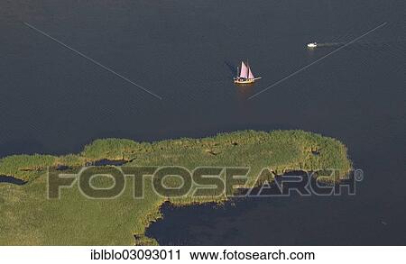 "Aerial view, flat-bottomed boat and a sailing ship in Barther Bodden lagoon off Grosser Kirr Island, Kirr island, Zingst, Fischland-Darss-Zingst, Mecklenburg-Western Pomerania, Germany, Europe" View Large Photo Image Stock Image - "Aerial view, flat-bottomed boat and a sailing ship in Barther Bodden lagoon off Grosser Kirr Island, Kirr island, Zingst, Fischland-Darss-Zingst, Mecklenburg-Western Pomerania, Germany, Europe". Fotosearch