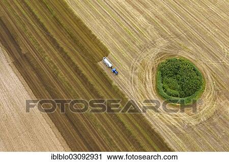 "Aerial view, harvested field with a forest island, tractor spreading slurry, Gross Kedingshagen, Kramerhof, Mecklenburg-Western Pomerania, Germany, Europe" View Large Photo Image Stock Image - "Aerial view, harvested field with a forest island, tractor spreading slurry, Gross Kedingshagen, Kramerhof, Mecklenburg-Western Pomerania, Germany, Europe". Fotosearch