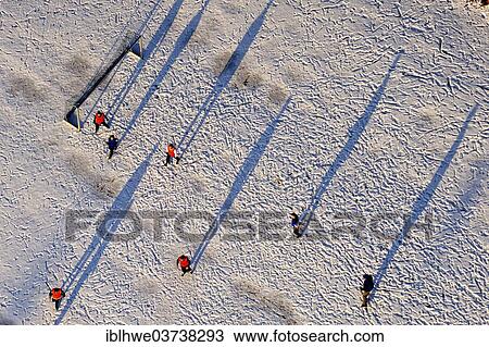 Stock Image - "Aerial view, Men's soccer team playing in the snow, Luneburg, Lower Saxony, Germany, Europe". Fotosearch