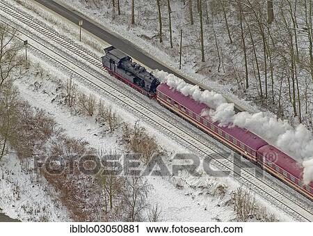 Stock Image - "Aerial view, train, steam engine with passenger cars, Neheim, Arnsberg, North Rhine-Westphalia, Germany, Europe". Fotosearch
