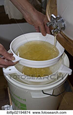 After the honey has been spun from the comb its filtered through two filters into the storage drum to remove any unwanted debris View Large Photo Image Picture - After the honey has been spun from the comb its filtered through two filters into the storage drum to remove any unwanted debris. Fotosearch