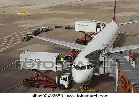 Aircraft is being prepared for the flight, elevating platform truck delivering goods for the galley, baggage car and airplane gangway attached to the aircraft, Duesseldorf International Airport, North Rhine-Westphalia, Germany, Europe View Large Photo Image Stock Photo - Aircraft is being prepared for the flight, elevating platform truck delivering goods for the galley, baggage car and airplane gangway attached to the aircraft, Duesseldorf International Airport, North Rhine-Westphalia, Germany, Europe. Fotosearch