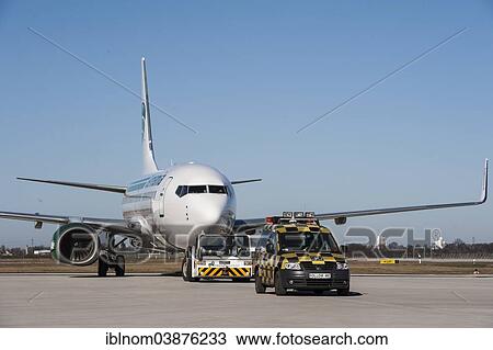 Stock Image - "Aircraft with a Follow-me Car, Airport Berlin Brandenburg International BBI, Berlin, Germany, Europe". Fotosearch