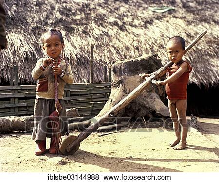 "Akha boy and Akha girl in torn clothes with primitive toys, wheel, Chiang Rai Province, Northern Thailand, Thailand, Asia" View Large Photo Image Stock Photo - "Akha boy and Akha girl in torn clothes with primitive toys, wheel, Chiang Rai Province, Northern Thailand, Thailand, Asia". Fotosearch