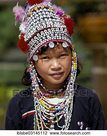 Stock Image - "Akha girl wearing a colourful headdress and the traditional costume of the mountain people, portrait, Mae Sai, Chiang Rai Province, Northern Thailand, Thailand, Asia". Fotosearch