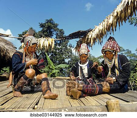 Stock Photography - "Akha women in a mountain village, in traditional costume and headdresses with silver coins, Chiang Rai Province, Northern Thailand, Thailand, Asia". Fotosearch
