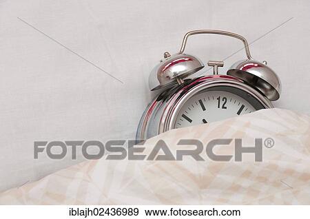 Alarm clock lying in a bed View Large Photo Image Stock Photo - Alarm clock lying in a bed. Fotosearch