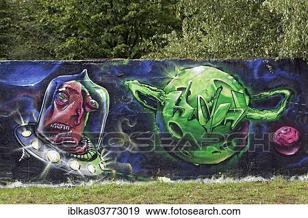Stock Photo - "Alien shooting towards a green planet, graffiti, North Rhine-Westphalia, Germany, Europe". Fotosearch