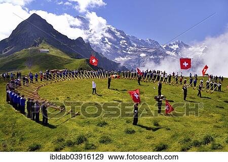 "Alphorn blowers and flag throwers, Grosses Alphorntreffen festival, on Mannlichen mountain, Kleine Scheidegg pass, Canton of Bern, Switzerland, Europe" View Large Photo Image Stock Photo - "Alphorn blowers and flag throwers, Grosses Alphorntreffen festival, on Mannlichen mountain, Kleine Scheidegg pass, Canton of Bern, Switzerland, Europe". Fotosearch