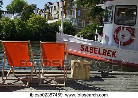Stock Photo - "Alster river steamer on the Osterbekkanal canal, deck chairs on the Muehlenkamp pier, Hamburg, Hamburg, Germany, Europe". Fotosearch