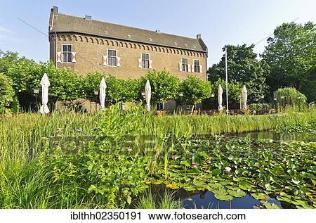 Stock Image - "Altes Schloss, old castle, with terrace of the restaurant and pond, Grevenbroich, North Rhine-Westphalia, Germany, Europe". Fotosearch