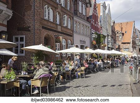 Stock Image - "Am Stintmarkt with people sitting outside restaurants, Luneburg, Lower Saxony, Germany, Europe". Fotosearch