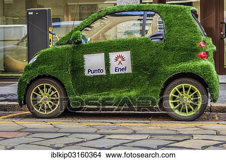 Picture - "An electric Smart car with grass cover, Punto and Enel markings, Milan, Lombardy, Italy, Europe". Fotosearch