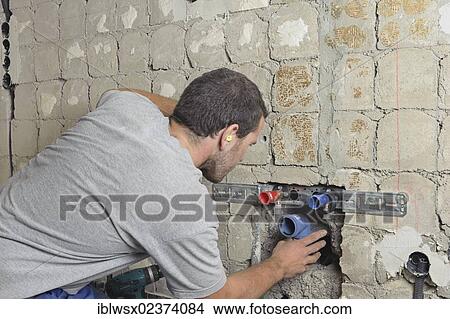 "An electrician, systems mechanic for sanitary engineering, heating and air conditioning, installing a sewer pipe, refurbishment, Baden-Wuerttemberg, Germany, Europe" View Large Photo Image Picture - "An electrician, systems mechanic for sanitary engineering, heating and air conditioning, installing a sewer pipe, refurbishment, Baden-Wuerttemberg, Germany, Europe". Fotosearch