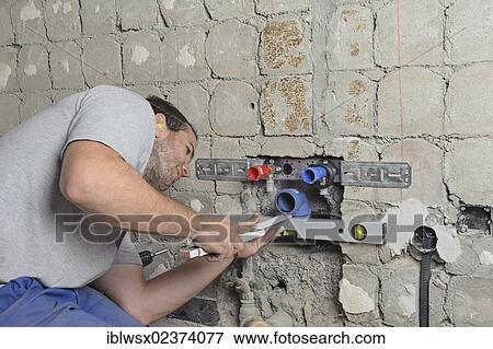 "An electrician, systems mechanic for sanitary engineering, heating and air conditioning, installing a sewer pipe, refurbishment, Baden-Wuerttemberg, Germany, Europe" View Large Photo Image Stock Photo - "An electrician, systems mechanic for sanitary engineering, heating and air conditioning, installing a sewer pipe, refurbishment, Baden-Wuerttemberg, Germany, Europe". Fotosearch