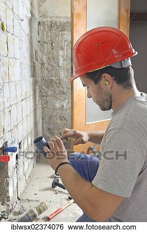 "An electrician, systems mechanic for sanitary engineering, heating and air conditioning, installing a sewer pipe, refurbishment, Baden-Wuerttemberg, Germany, Europe" View Large Photo Image Stock Photograph - "An electrician, systems mechanic for sanitary engineering, heating and air conditioning, installing a sewer pipe, refurbishment, Baden-Wuerttemberg, Germany, Europe". Fotosearch