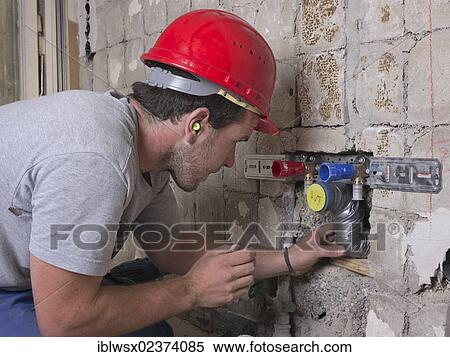 "An electrician, systems mechanic for sanitary engineering, heating and air conditioning, installing a sewer pipe, refurbishment, Baden-Wuerttemberg, Germany, Europe" View Large Photo Image Stock Photography - "An electrician, systems mechanic for sanitary engineering, heating and air conditioning, installing a sewer pipe, refurbishment, Baden-Wuerttemberg, Germany, Europe". Fotosearch