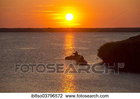 "Anglers with boats at sunset on the Bodstedter Bodden lagoon, near Wieck, Mecklenburg-Western Pomerania, Germany, Europe" View Large Photo Image Stock Image - "Anglers with boats at sunset on the Bodstedter Bodden lagoon, near Wieck, Mecklenburg-Western Pomerania, Germany, Europe". Fotosearch