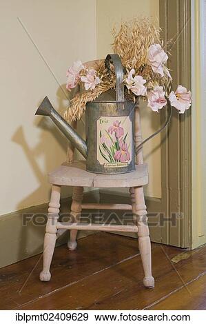 "Antique watering can on top of a small chair in an old Canadiana cottage style wooden siding residential home, circa 1741, Quebec, Canada - This image is property released for book, calendar, magazine, newspaper and editorial use only. " View Large Photo Image Stock Photo - "Antique watering can on top of a small chair in an old Canadiana cottage style wooden siding residential home, circa 1741, Quebec, Canada - This image is property released for book, calendar, magazine, newspaper and editorial use only. ". Fotosearch