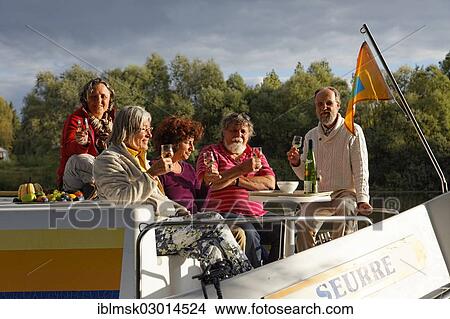 "Aperitif in the evening sun, on the bow terrace of a Penichette, a houseboat on the Saone River in a quiet tributary, in the Saone Valley Marina, Traves, Vesoul, Region Franche-Comte, Dep. Haute-Saone, France, Europe" View Large Photo Image Picture - "Aperitif in the evening sun, on the bow terrace of a Penichette, a houseboat on the Saone River in a quiet tributary, in the Saone Valley Marina, Traves, Vesoul, Region Franche-Comte, Dep. Haute-Saone, France, Europe". Fotosearch
