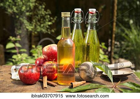 "Apples with apple cider vinegar and apple juice on a wooden box in the garden, Germany, Europe" View Large Photo Image Stock Photography - "Apples with apple cider vinegar and apple juice on a wooden box in the garden, Germany, Europe". Fotosearch