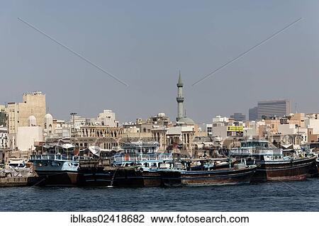 Stock Image - Arab dhows or daus on Dubai Creek, Deira district, Dubai, United Arab Emirates, Middle East, Asia. Fotosearch