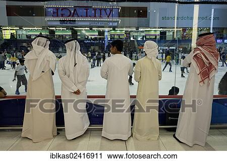 Arabs wearing traditional white dishdasha robes watching ice skaters, Dubai Ice Rink, Dubai Mall, United Arab Emirates, Middle East, Asia View Large Photo Image Stock Image - Arabs wearing traditional white dishdasha robes watching ice skaters, Dubai Ice Rink, Dubai Mall, United Arab Emirates, Middle East, Asia. Fotosearch