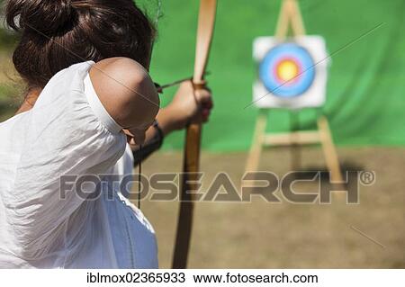 Stock Image - "Archer aiming bow and arrow at target, Hesse, Germany, Europe". Fotosearch