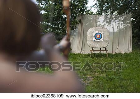 "Archery, woman aiming bow and arrow at a target, Germany, Europe" View Large Photo Image Stock Photo - "Archery, woman aiming bow and arrow at a target, Germany, Europe". Fotosearch