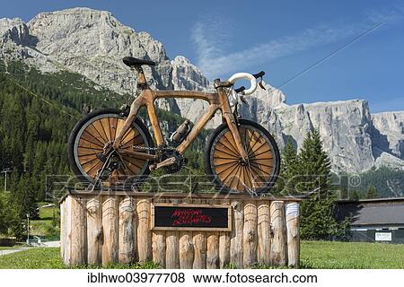 "Art installation, wooden bicycle, symbol of Maratona dles Dolomites, the Sella Group at the back, Corvara, Region of Trentino-Alto Adige, Italy, Europe" View Large Photo Image Stock Photo - "Art installation, wooden bicycle, symbol of Maratona dles Dolomites, the Sella Group at the back, Corvara, Region of Trentino-Alto Adige, Italy, Europe". Fotosearch