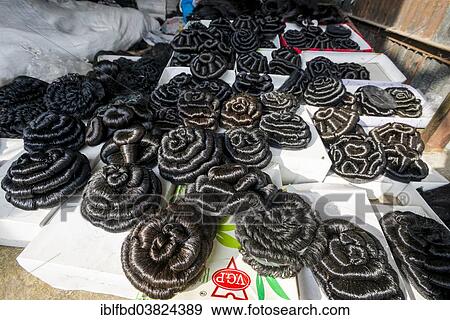 Stock Photo - "Artificial hair, braided to buns, for sale at the weekly market, Nasik, Maharashtra, India, Asia". Fotosearch