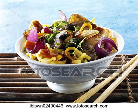 Stock Photograph - "Asian, vegetarian wok dish with vegetables, noodles and mushrooms in a bowl with chopsticks". Fotosearch