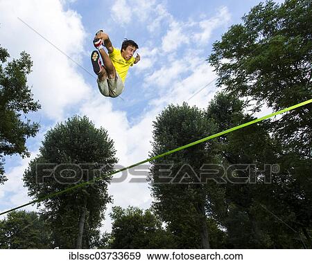 "Athlete jumping on a slackline, Waiblingen, Baden-Wurttemberg, Germany, Europe" View Large Photo Image Stock Photo - "Athlete jumping on a slackline, Waiblingen, Baden-Wurttemberg, Germany, Europe". Fotosearch