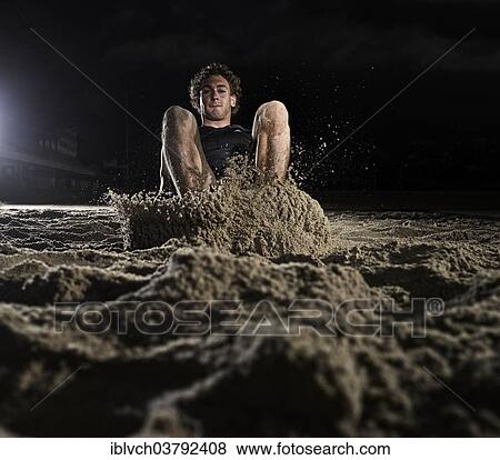 Athlete lands in the sand at the long jump View Large Photo Image Stock Photo - Athlete lands in the sand at the long jump. Fotosearch