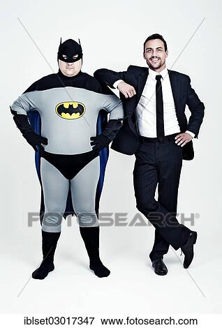 Stock Photo - "Athletic man wearing a suit beside a fat man dressed as a superhero, Batman". Fotosearch