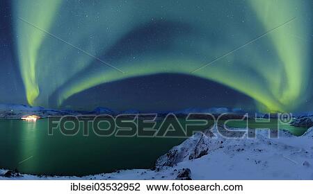Stock Image - "Aurora over a fjord with snow-covered mountains, Tromso, â€ªTroms, Northern Norway, Norway, Europe". Fotosearch